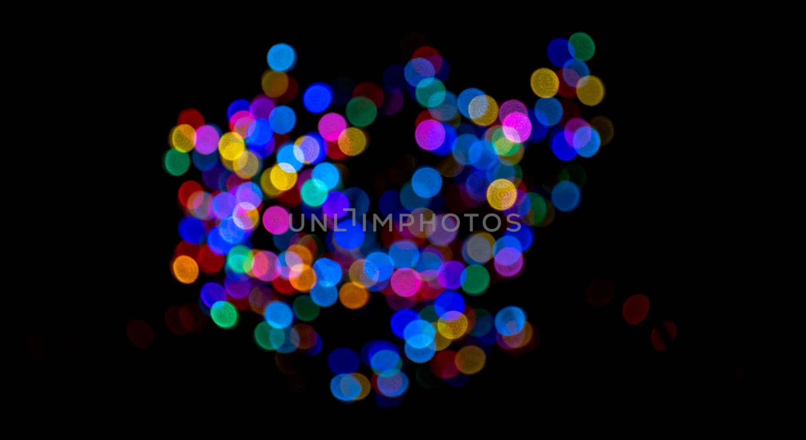 Colorful group of holiday lights on dark background of night