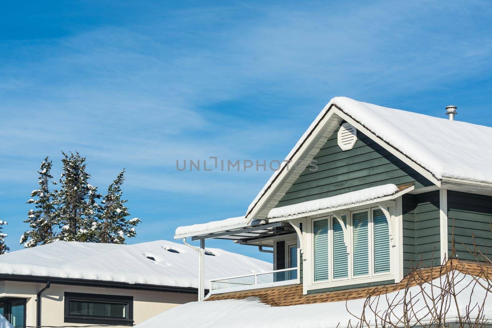 Top of residential house in snow on sunny winter day in Canada