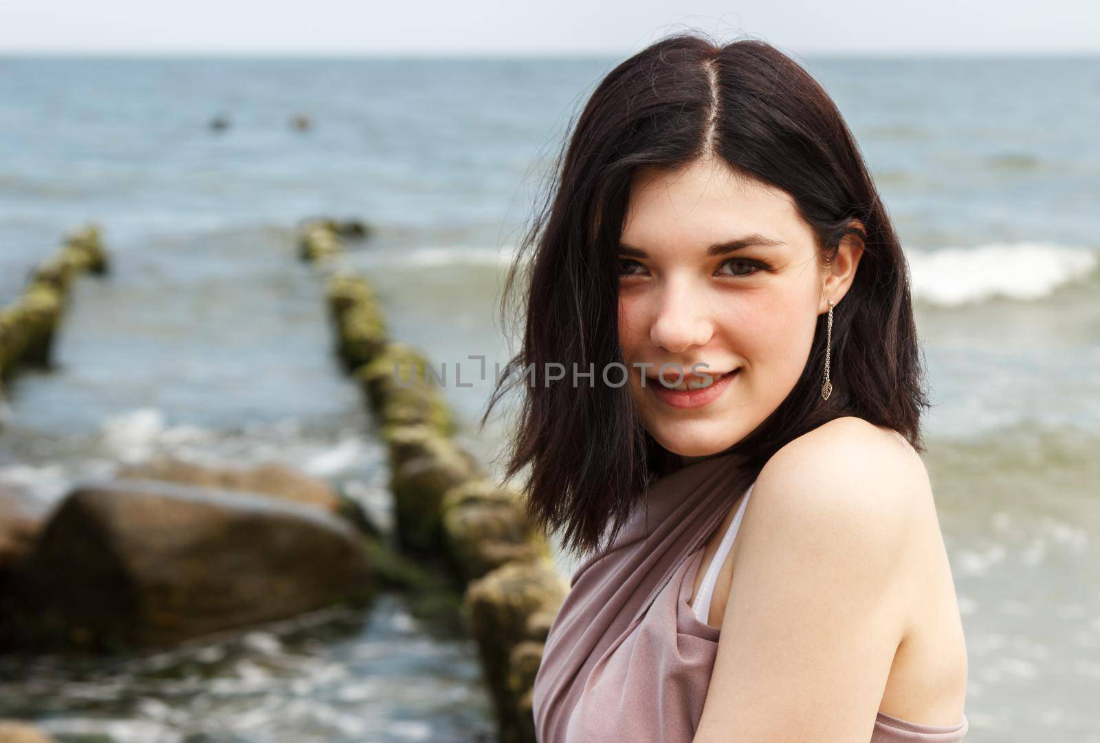 young beautiful brunette woman by the sea by raddnatt
