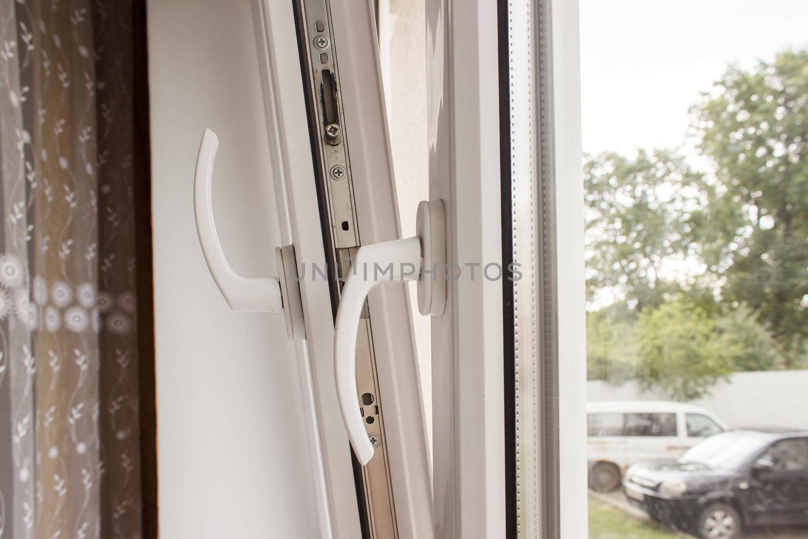 handles of opened white plastic window indoor closeup