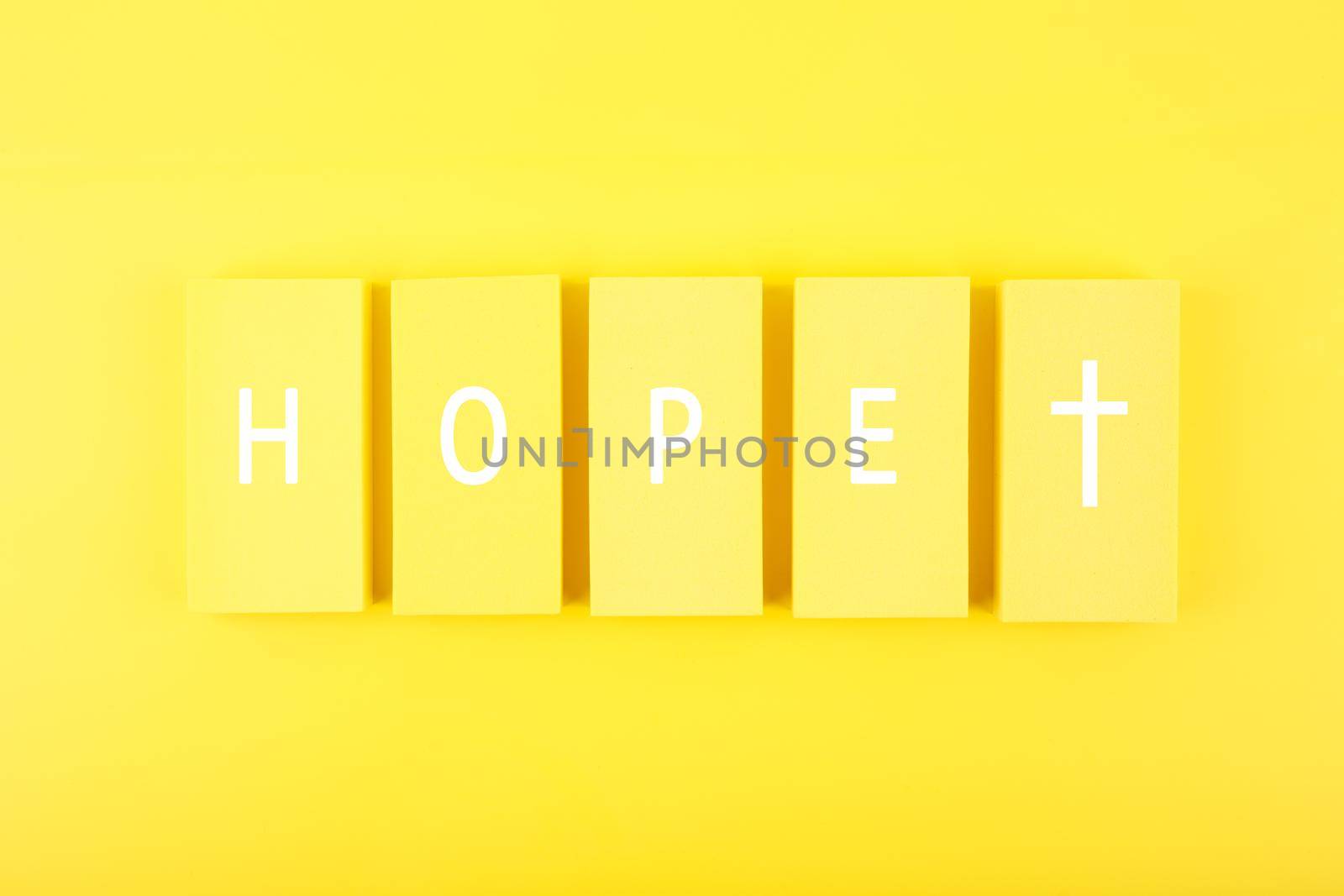 Modern religious minimal concept of hope with christian cross on bright yellow background by Senorina_Irina