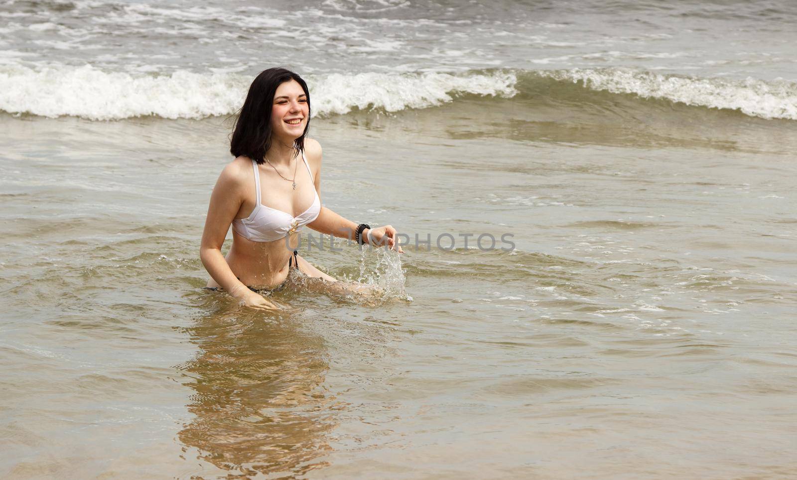 young woman swims in the sea by raddnatt