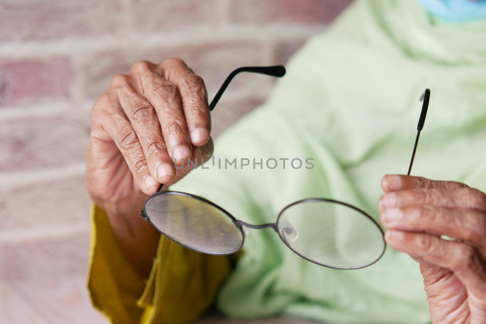 Close up of senior women hand holding old eyeglass by towfiq007