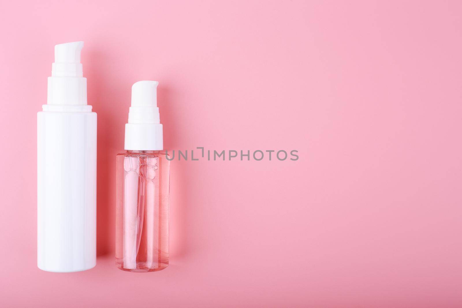 Face cream or lotion and liquid foam or gel for skin cleaning on pink background with copy space. Concept of daily skin care treatment, cleaning, exfoliating and moisturizing