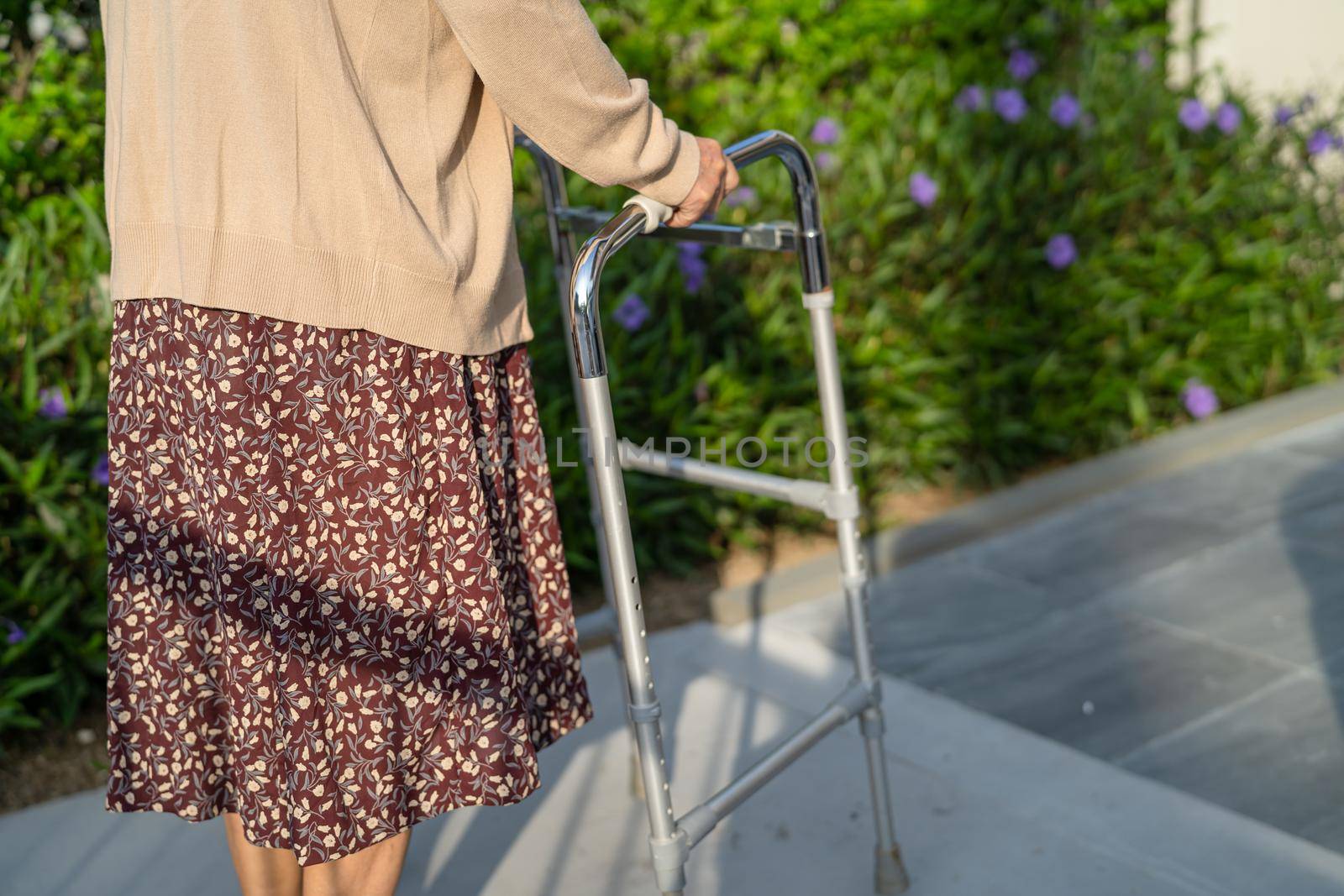 Asian senior or elderly old lady woman patient walk with walker in park with copy space, healthy strong medical concept by pamai