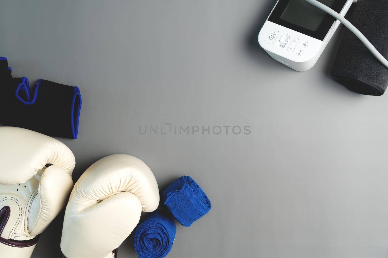 Boxing glove, sphygmomanometer, fitness equipment on gray background with copy space