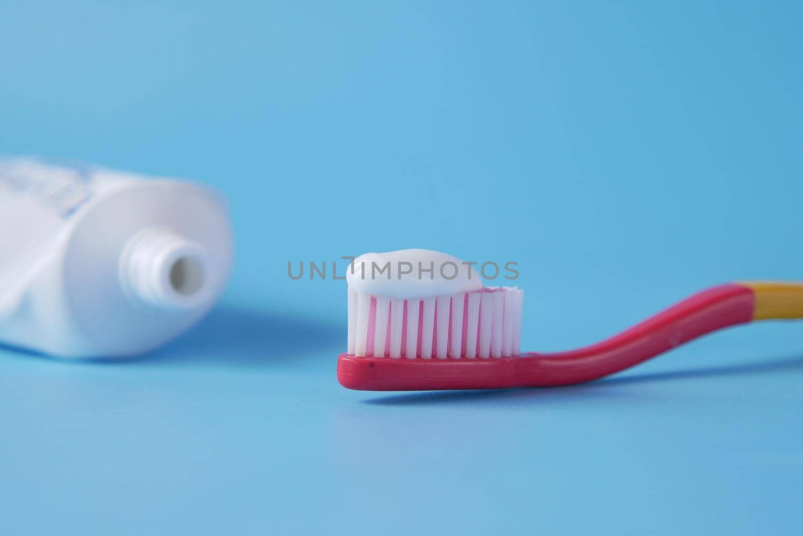 tooth brush with paste on blue background .