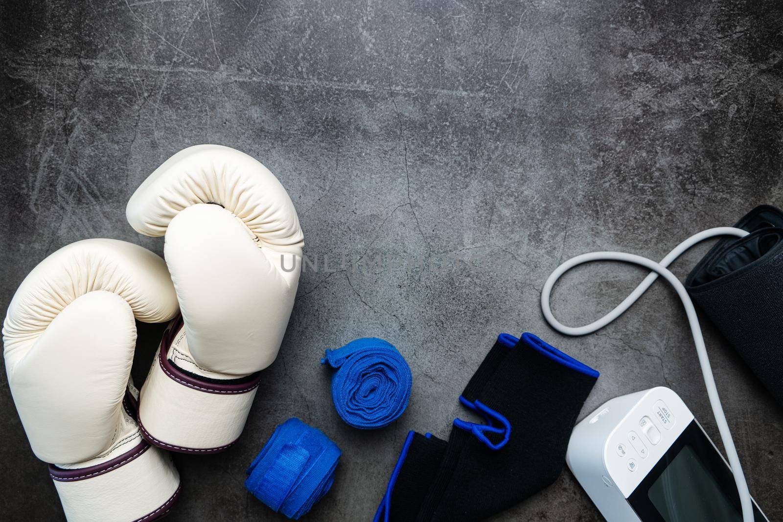 Boxing glove, sphygmomanometer, fitness equipment on a dark background with copy space