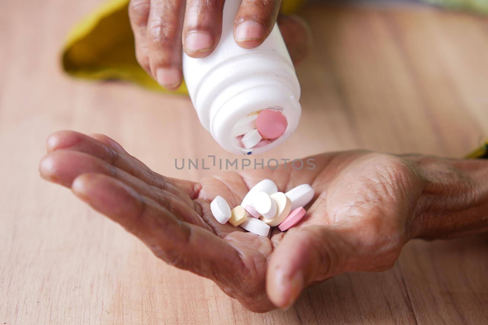 close up of pills and capsule on senior women's hand by towfiq007