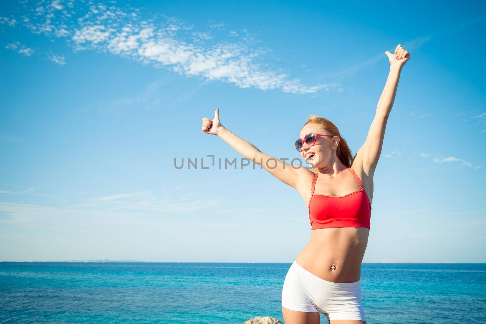 Beautiful young sensuous woman wearing sunglasses and fitness bikini