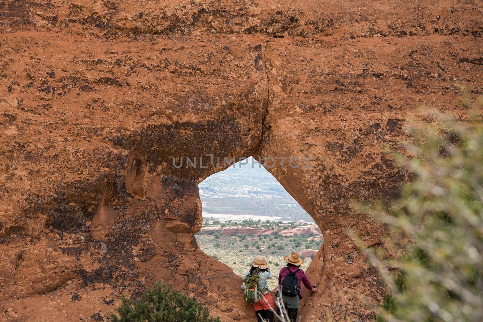 Couple looking through large window at Arches National Park