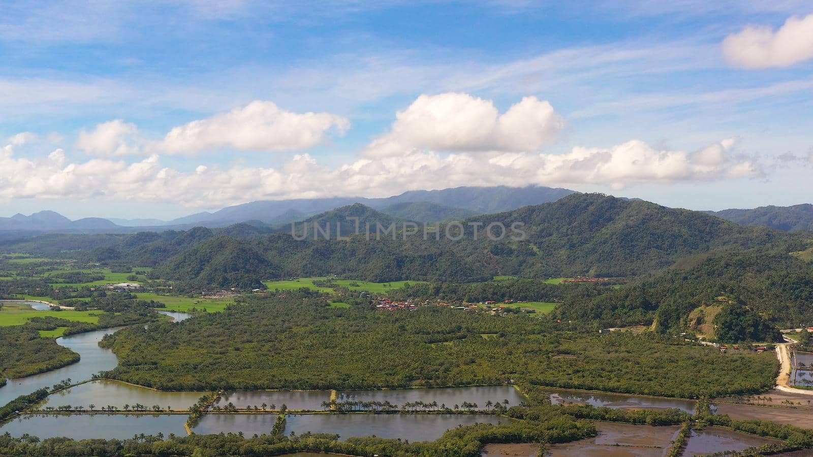 Tropical landscape: a town at the foot of mountains and hills covered with tropical vegetation and forest. Philippines, Mindanao. Surigao City.