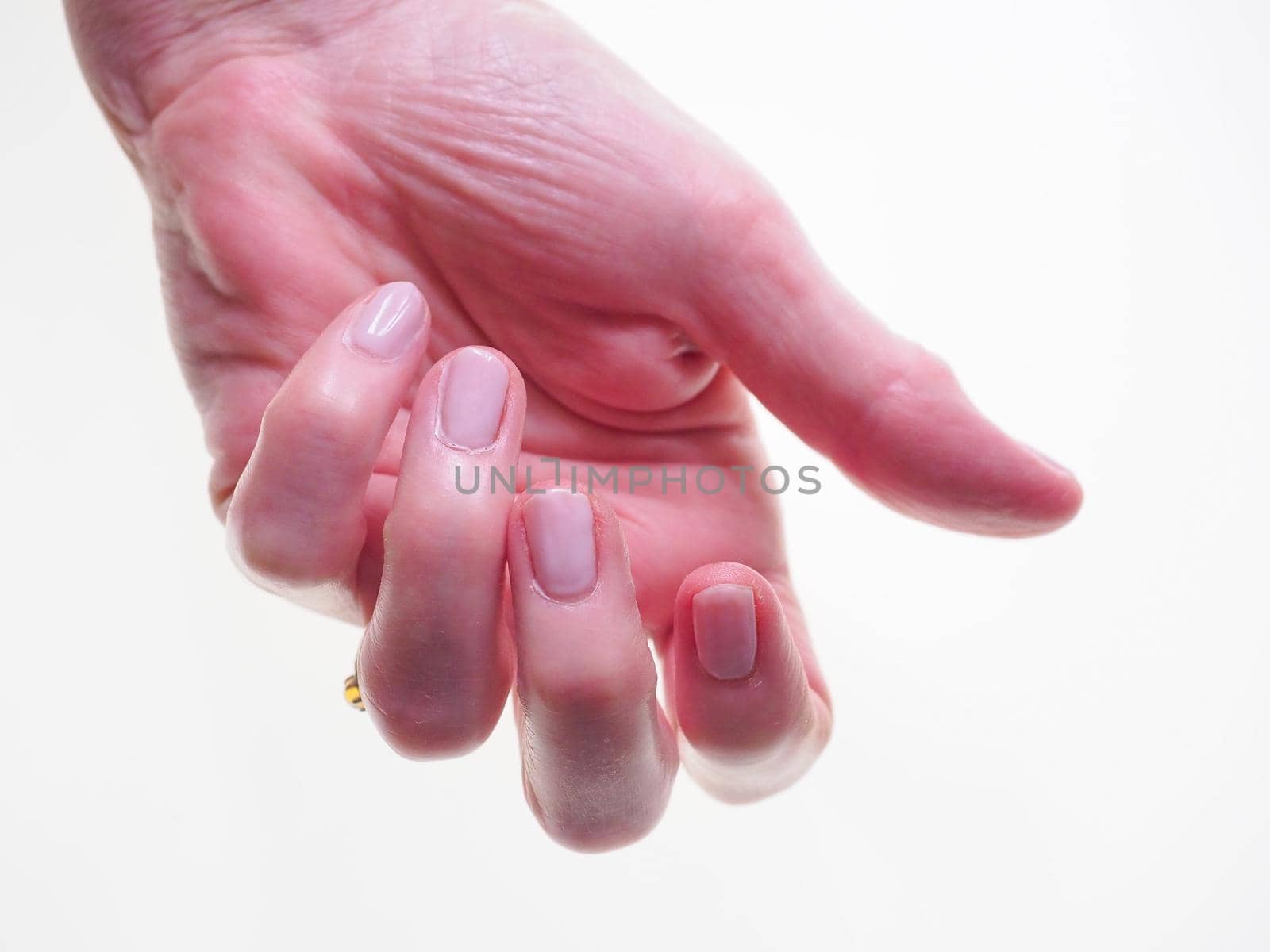 Studio photograph of pink painted nails on a ladies hand against a white background