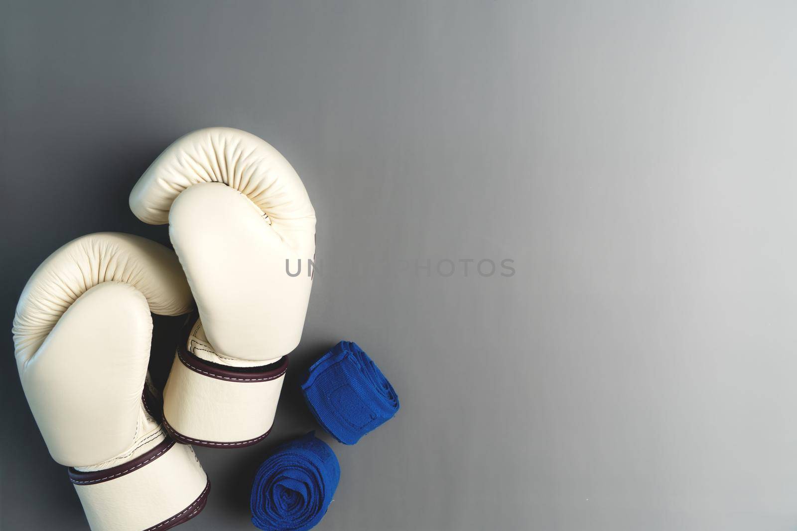 white boxing gloves with ankle support on grey background with copy space for text. by psodaz