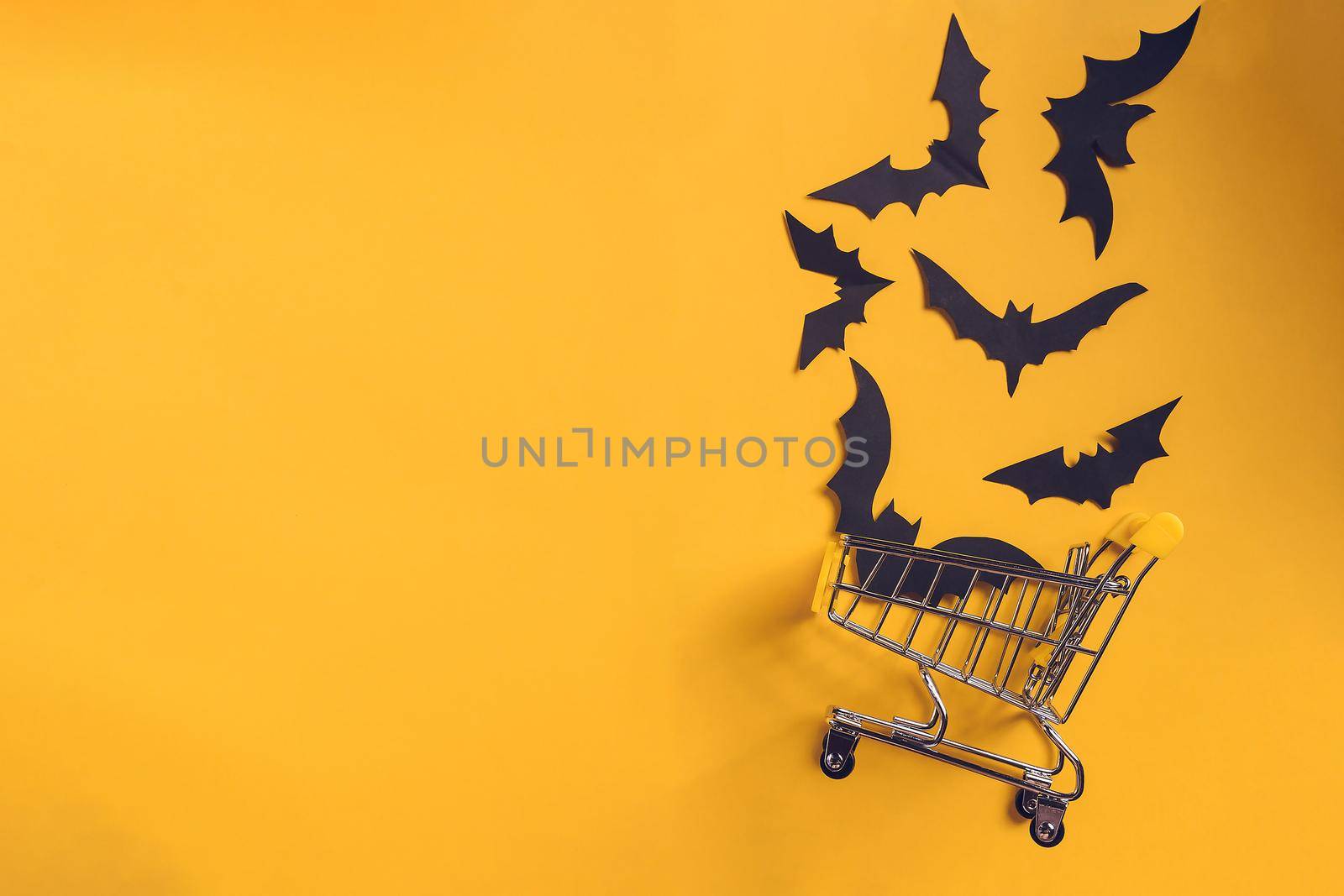 Festive halloween background with paper bats on a shopping trolley.Mock up flatly for party or sale. Top view.Copy Space