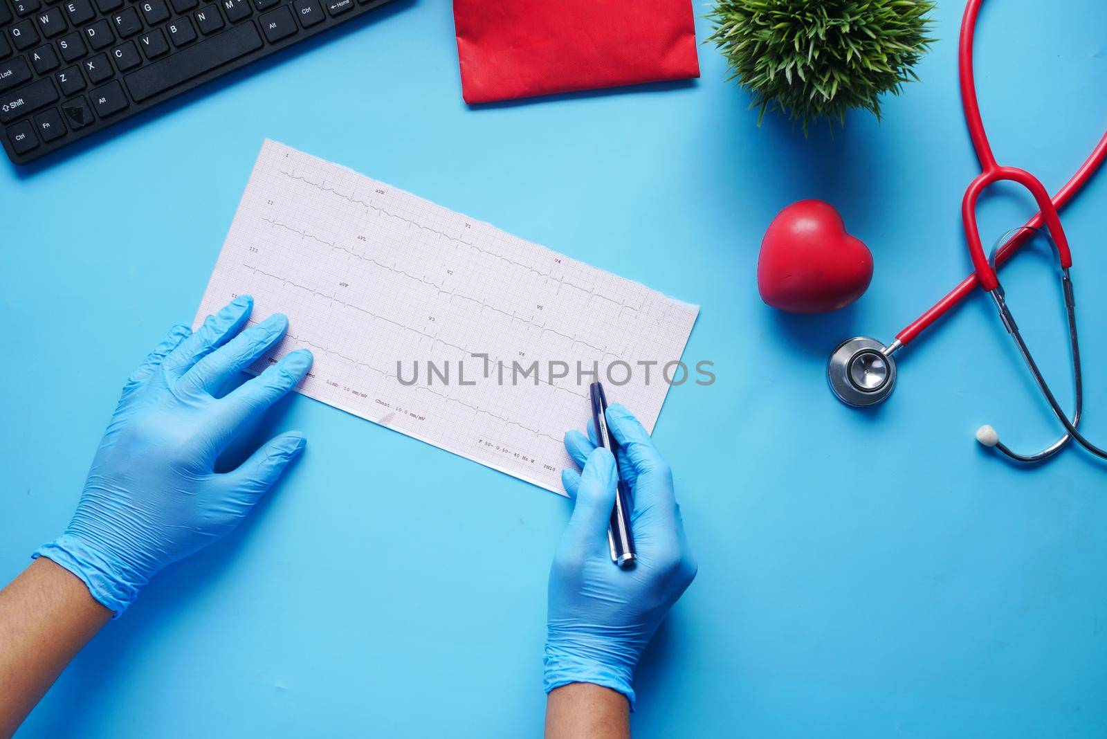 doctor hand in medical gloves analyzing cardio diagram.,