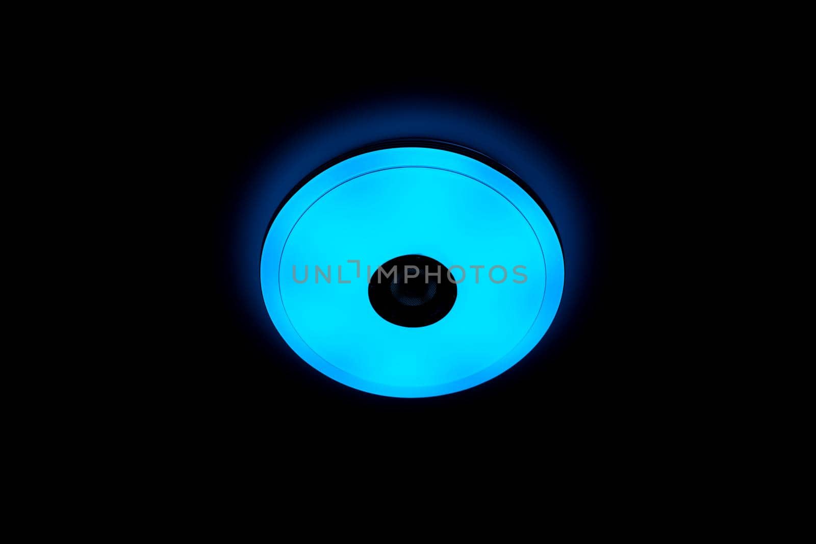 Blue light LED ceiling light with built-in wireless speakers over black background. by wattanaphob