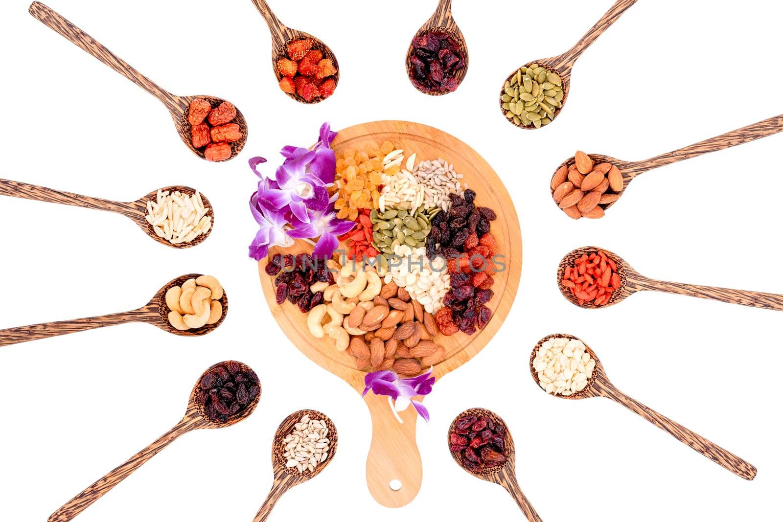 Top view group of whole grains and dried fruits 12 kinds with a beautiful orchid on a wooden plate and wooden spoons isolated on white background. by wattanaphob