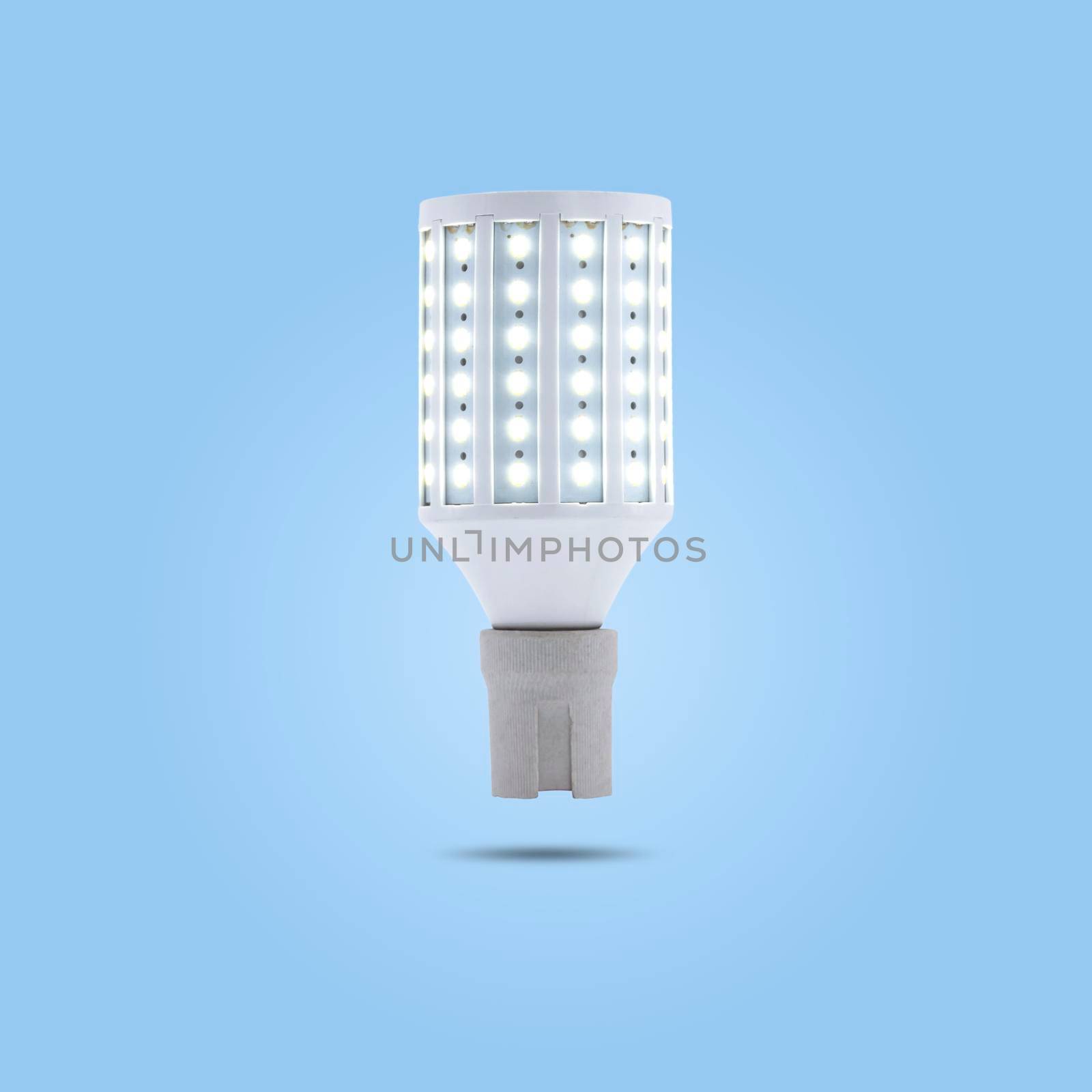 LED energy saving lamp 230v in a ceramic socket isolated on blue pastel color background. by wattanaphob