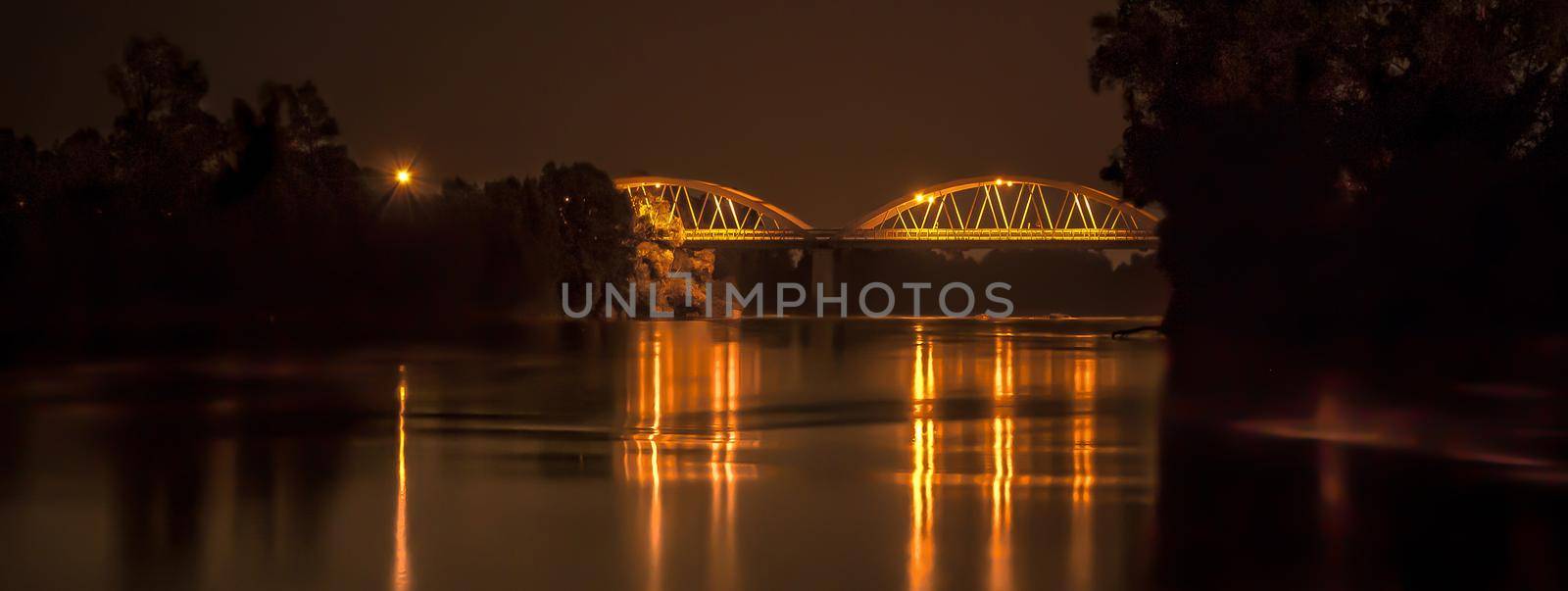 Bridge over the river illuminated at night, banner image with copy space