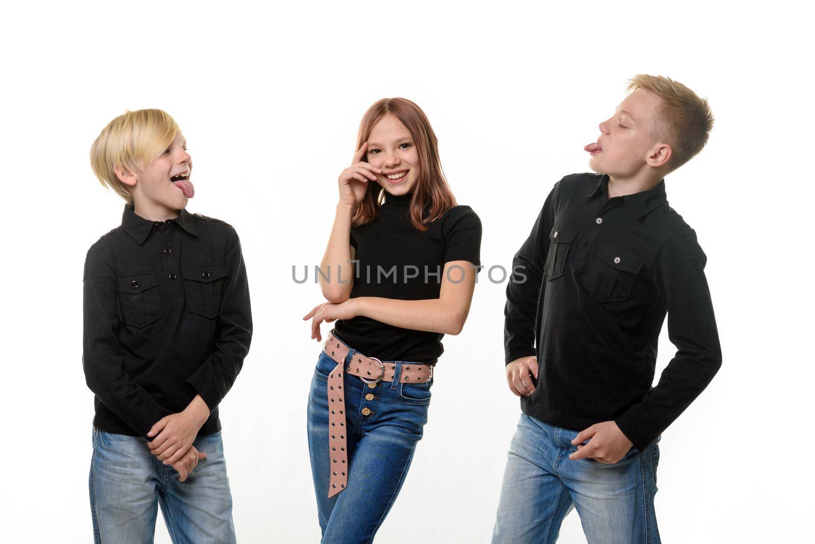 Happy girl surrounded by boring brothers, brothers show tongue to sister