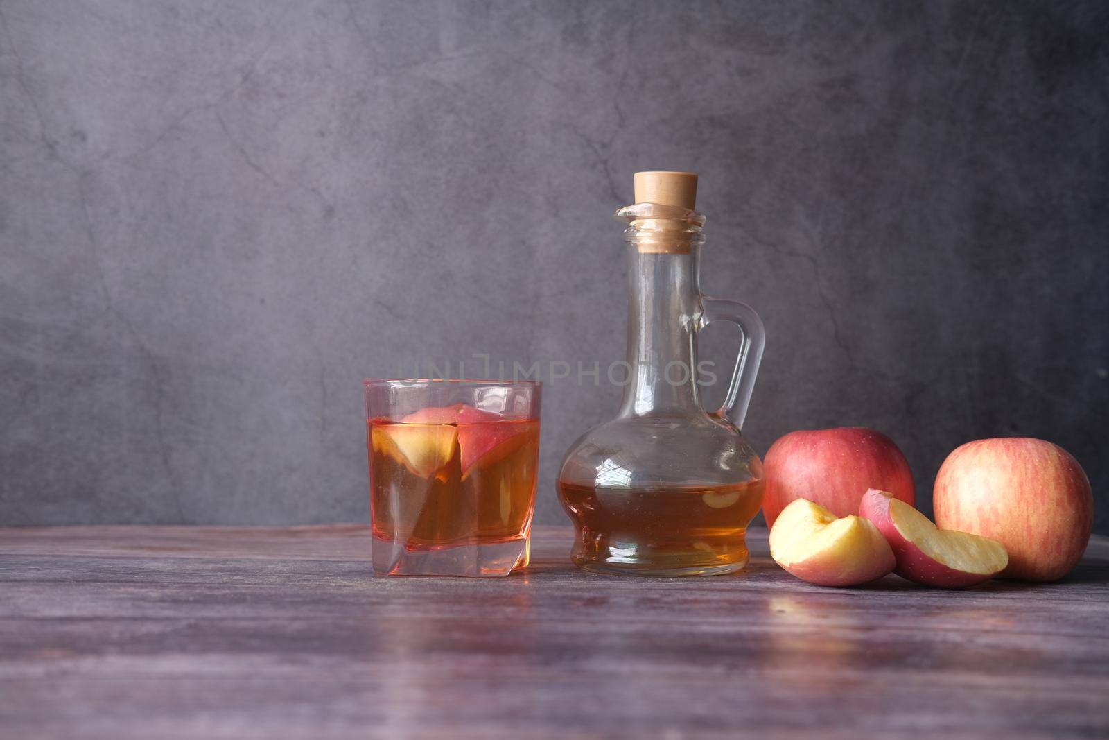 apple vinegar in glass bottle with fresh green apple on table by towfiq007