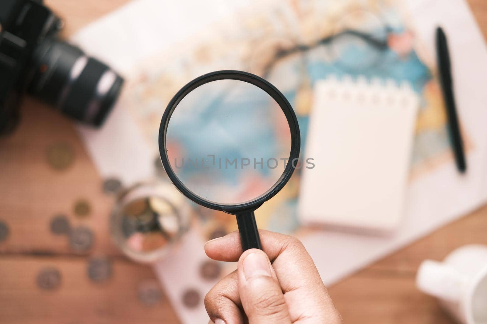 young man using magnifying glass looking something on map ,