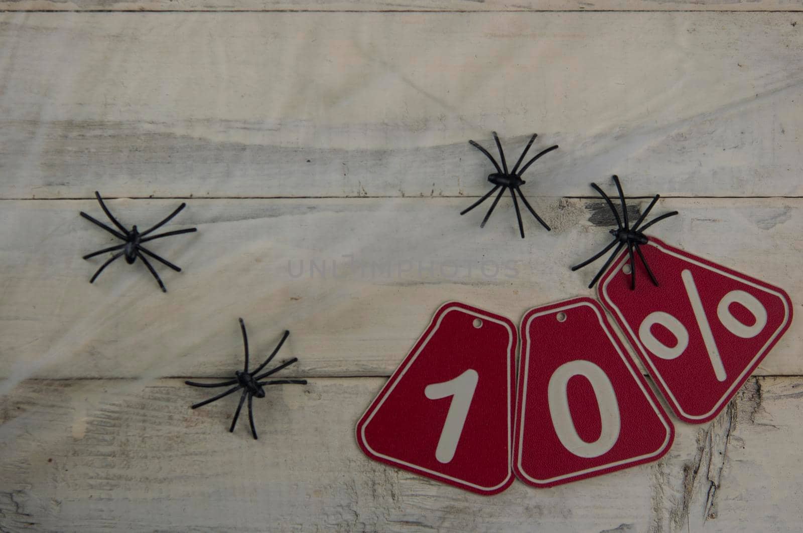 ten percent discount on Halloween background - price tag on a rustic old wooden background by inxti