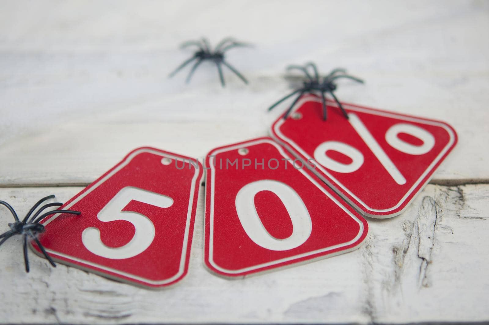 fifty percent discount on Halloween background-price tag on a rustic old wooden background by inxti
