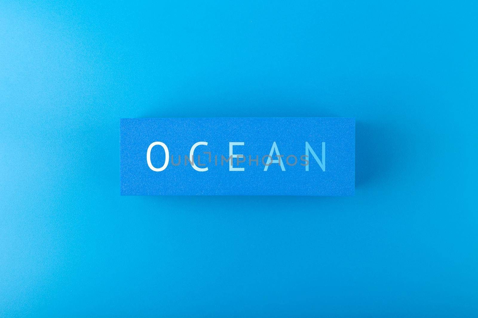 Single word ocean on dark blue background with gradient. Concept of ocean pollution with plastic garbage, ecology poster or Ocean day poster or banner