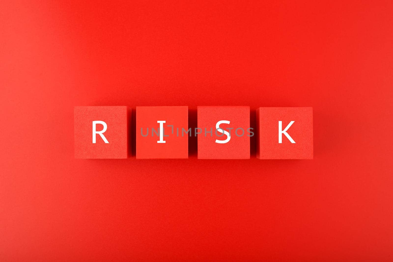 Risk single word written on red cubes against red background. Concept of risk and danger in business, social life, health, life style decisions or strategy