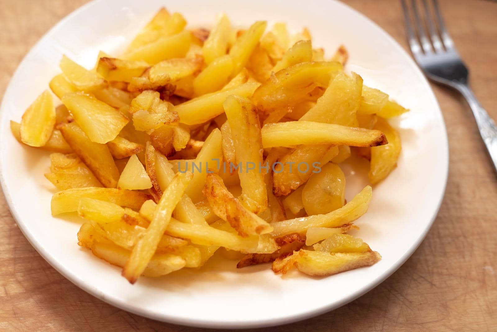 Fresh golden chips on a white plate. Delicious vegetable dish by levnat09