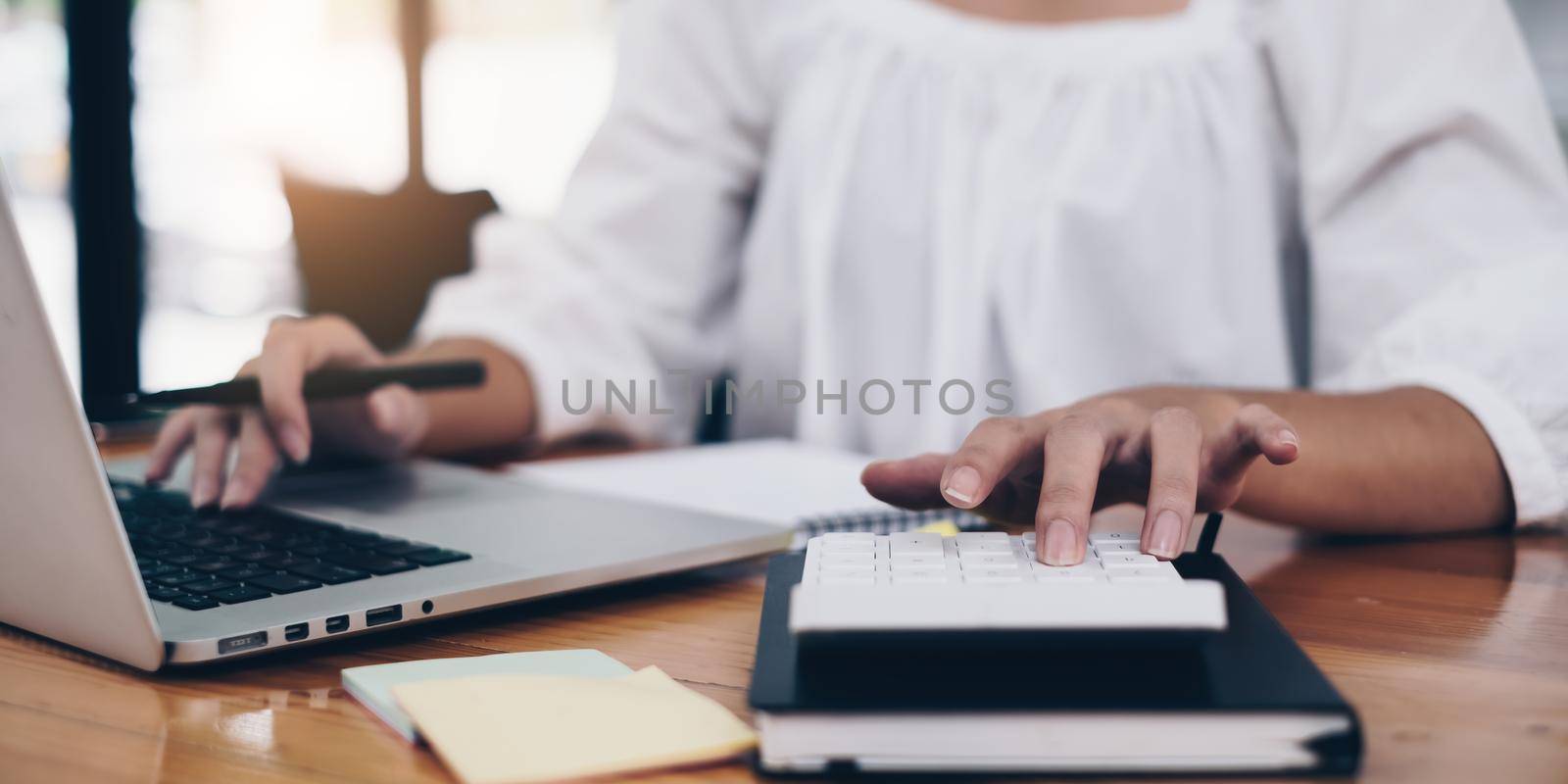 Business woman hand using laptop and calculator. Account or saving money or insurance concept by itchaznong