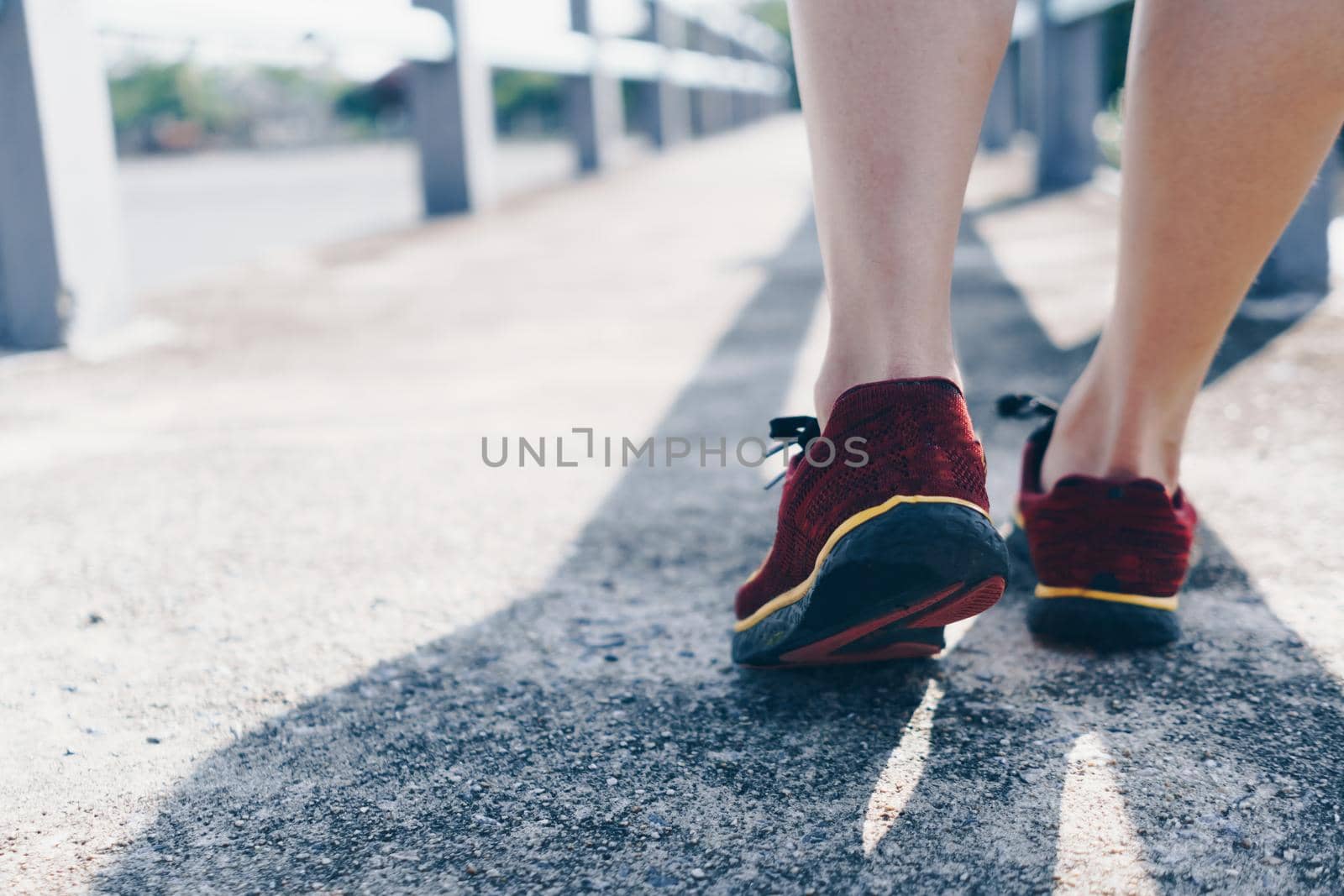 Woman wear running shoe on to walking and running on nature green background.Health exercise. by Suwant