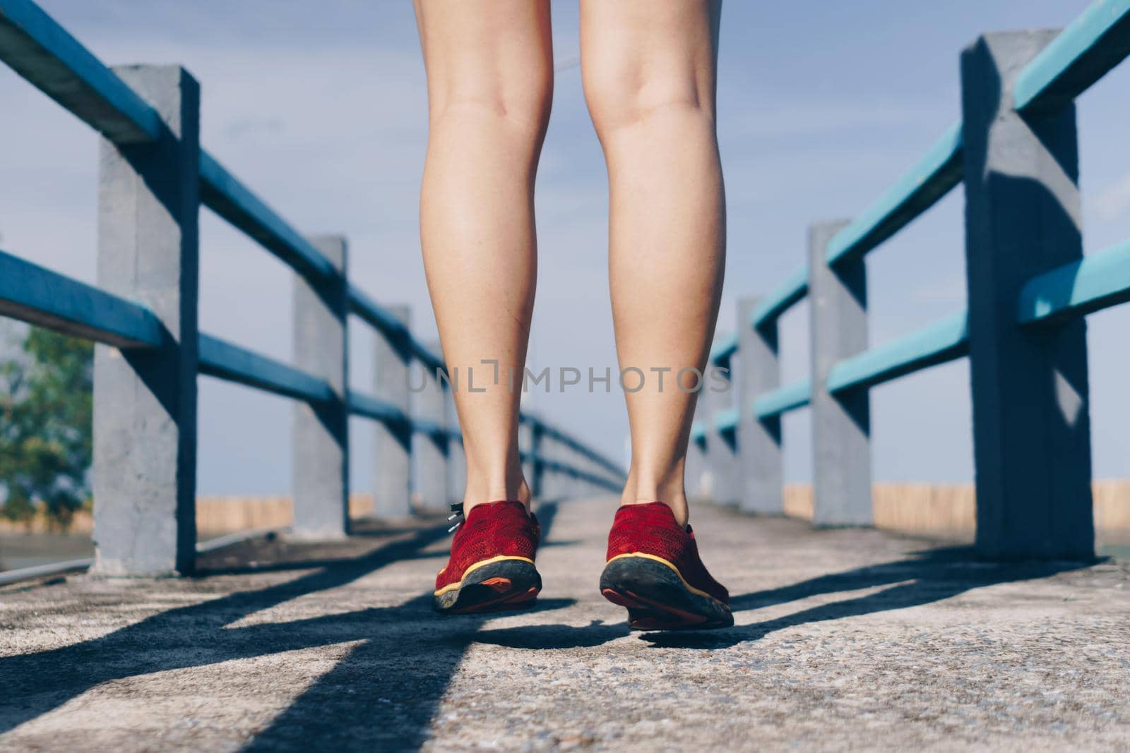 On a green background, a woman walks and runs while wearing running shoes. Exercise for health is a notion.