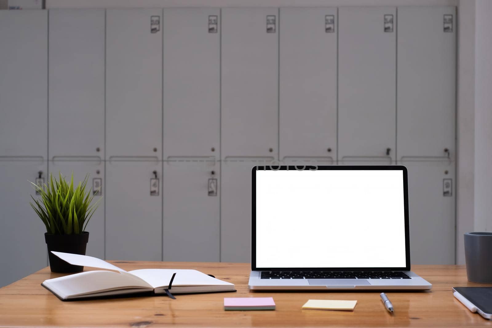 Image of Mock up laptop computer on wooden desk in office. Blank screen for your advertising by itchaznong