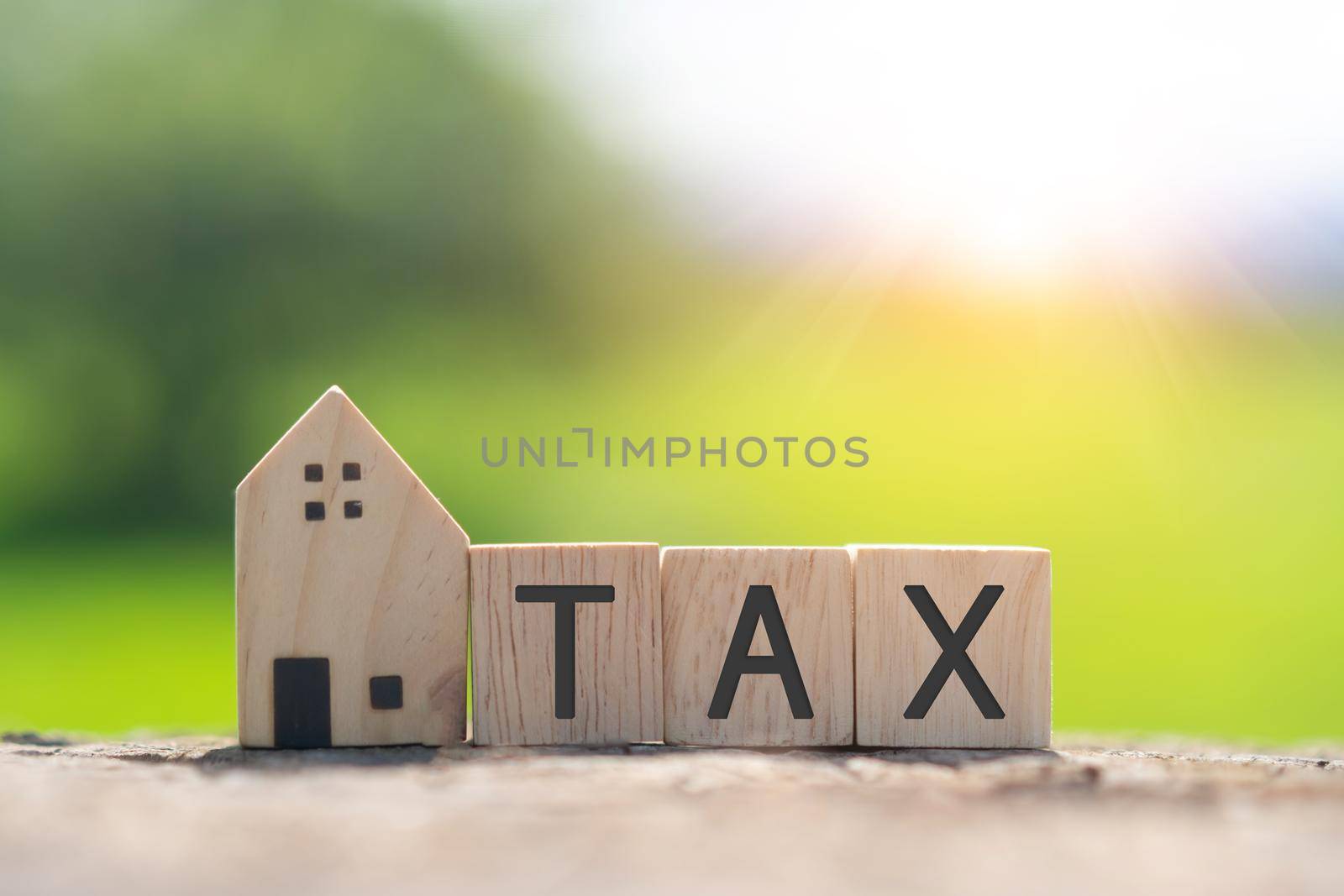 On a wooden cube background, the word tax appears. The concept of a business financial loan. by Suwant