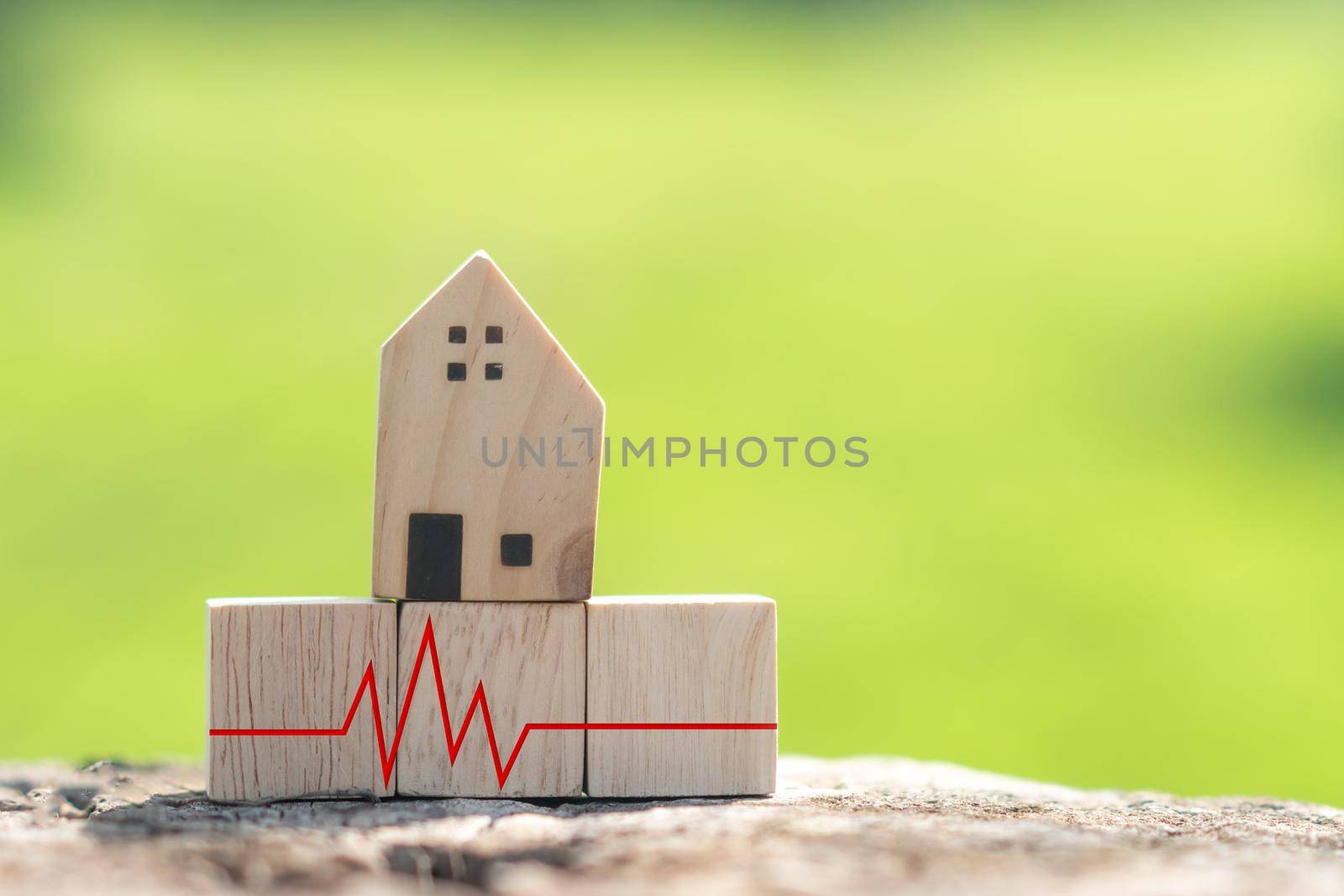 The concept of a crisis situation time financial difficulty is represented by a wooden cube with a house model and a heart pulse. by Suwant