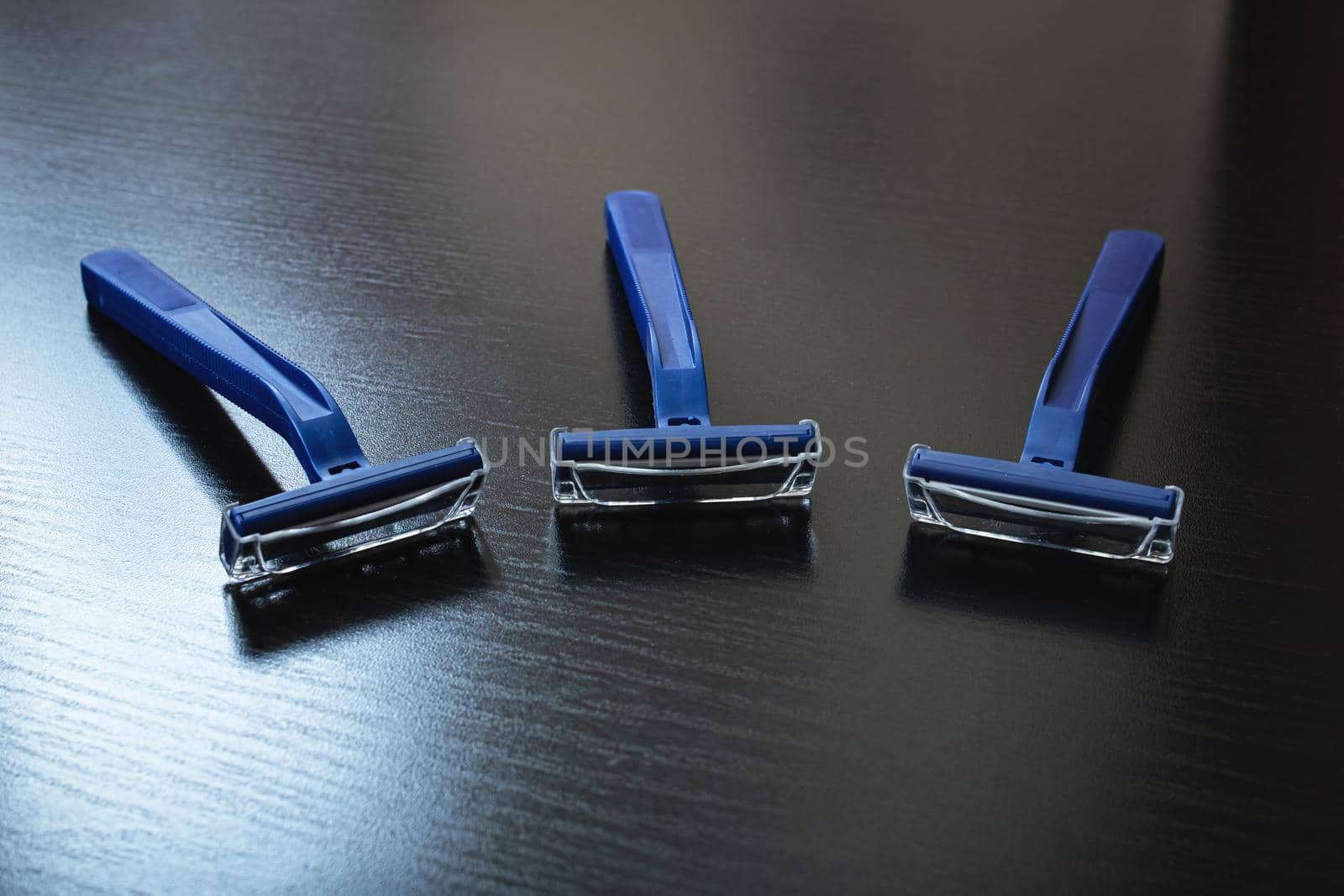 Three blue razors on a wooden background by Vera1703