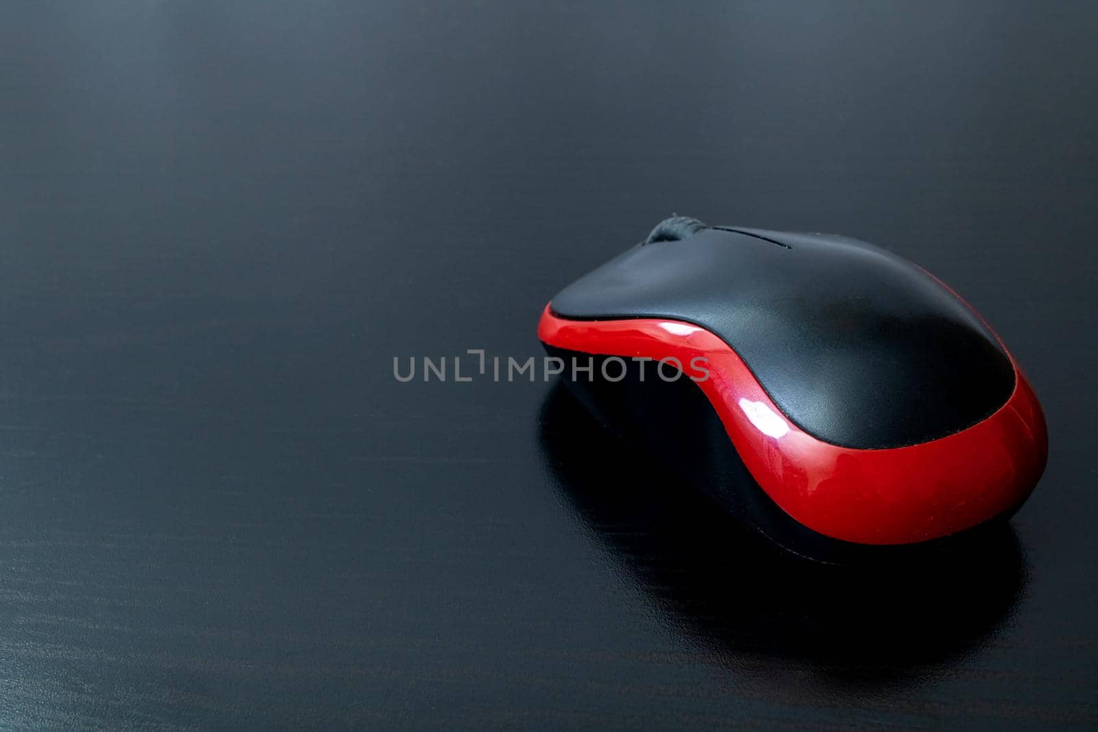 Black computer mouse on a wooden table, copy space