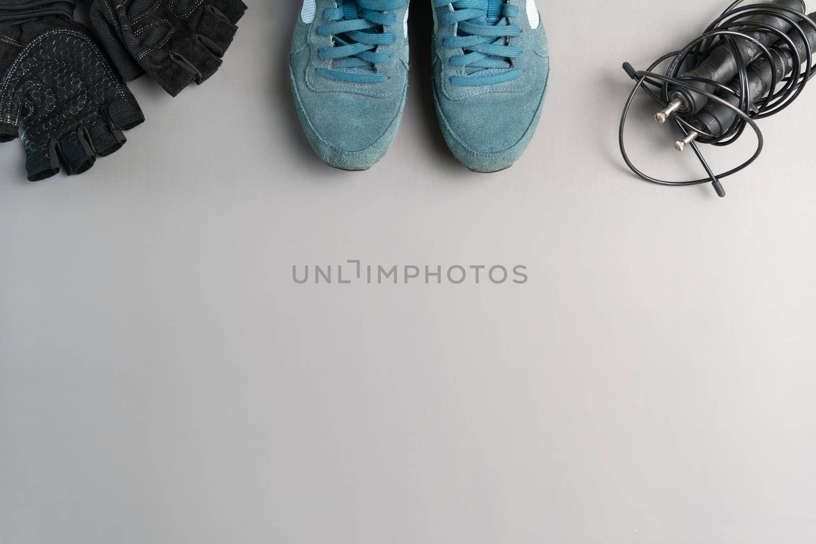 Healthy lifestyle. Jump rope  equipment on a grey background. Top view with copy space. by psodaz