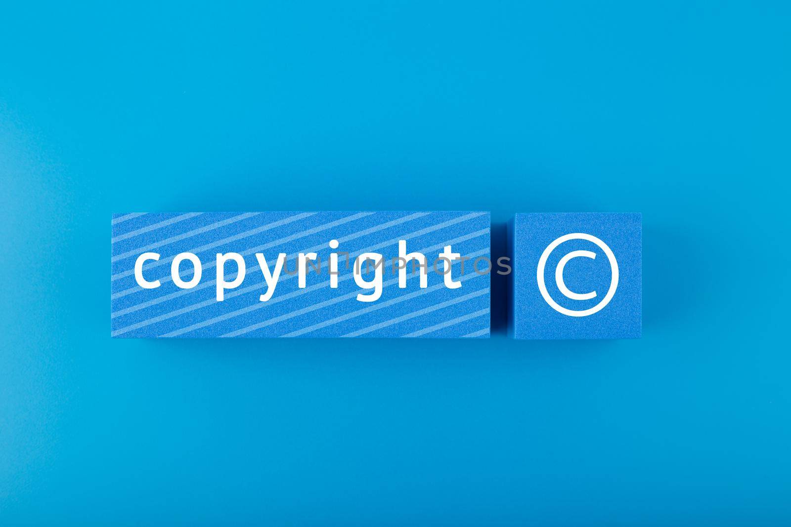 Minimal trendy copyright and patenting concept. Copyright word and symbol on blue blocks against blue background