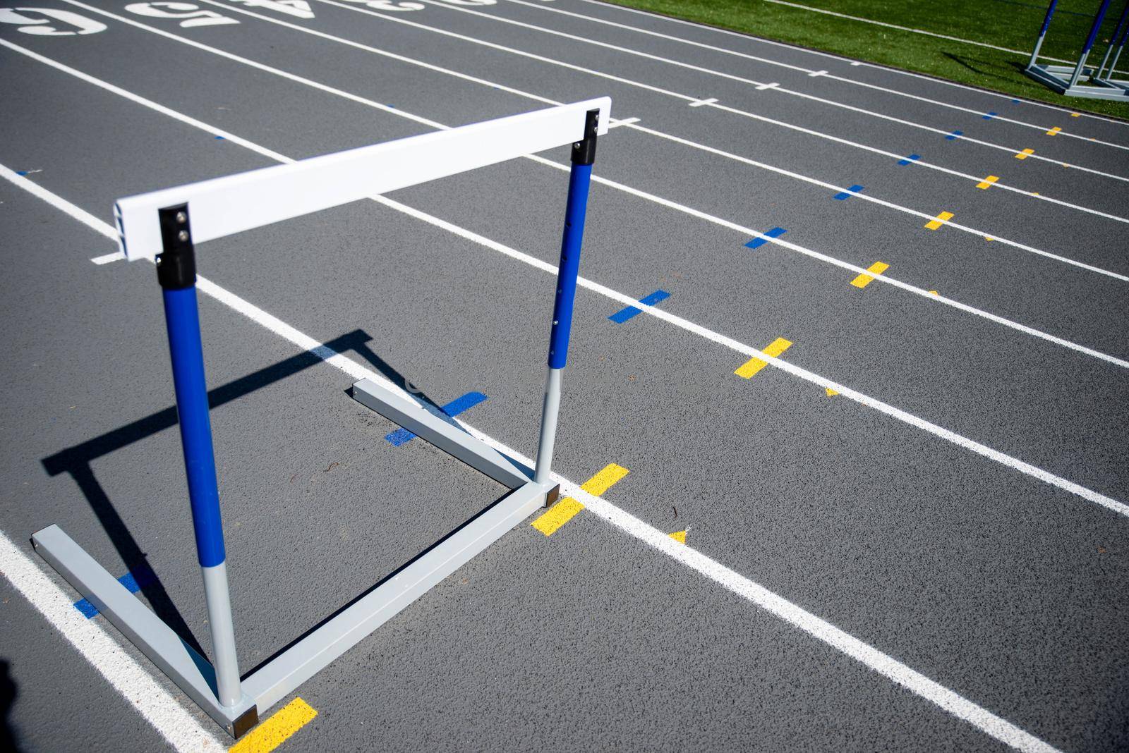 One hurdle in place on an athletic running track by marysalen