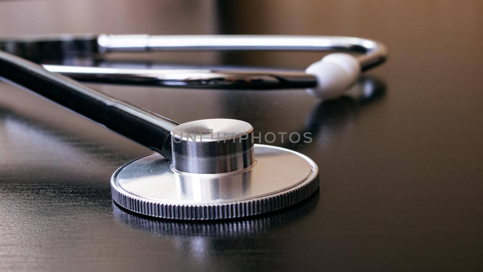 Medical stethoscope on a black table closeup by Vera1703