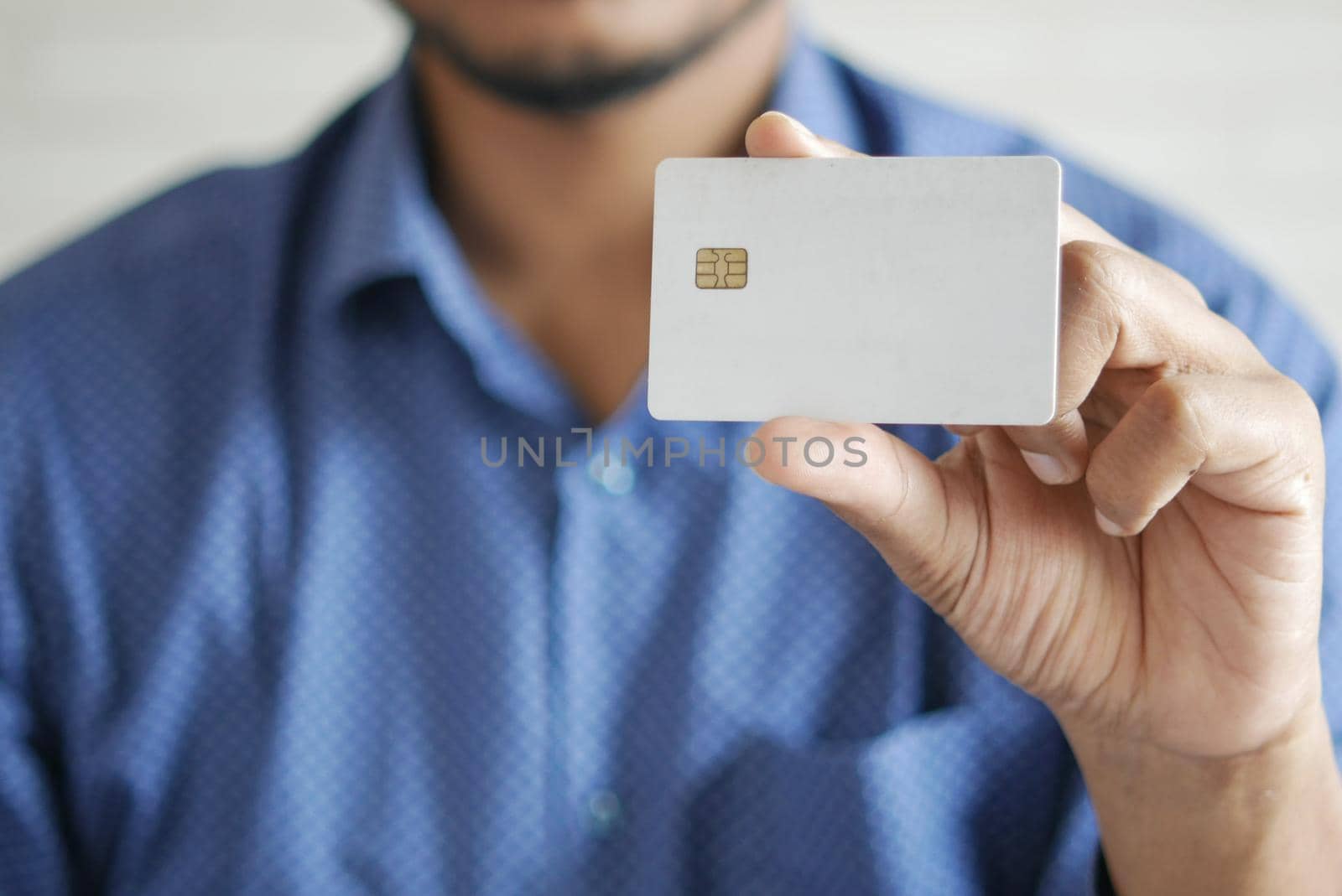 Man in casual dress showing credit card.