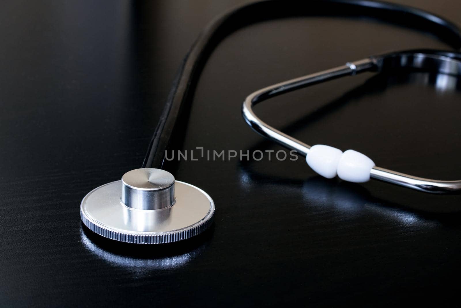 Medical stethoscope on a black table closeup by Vera1703