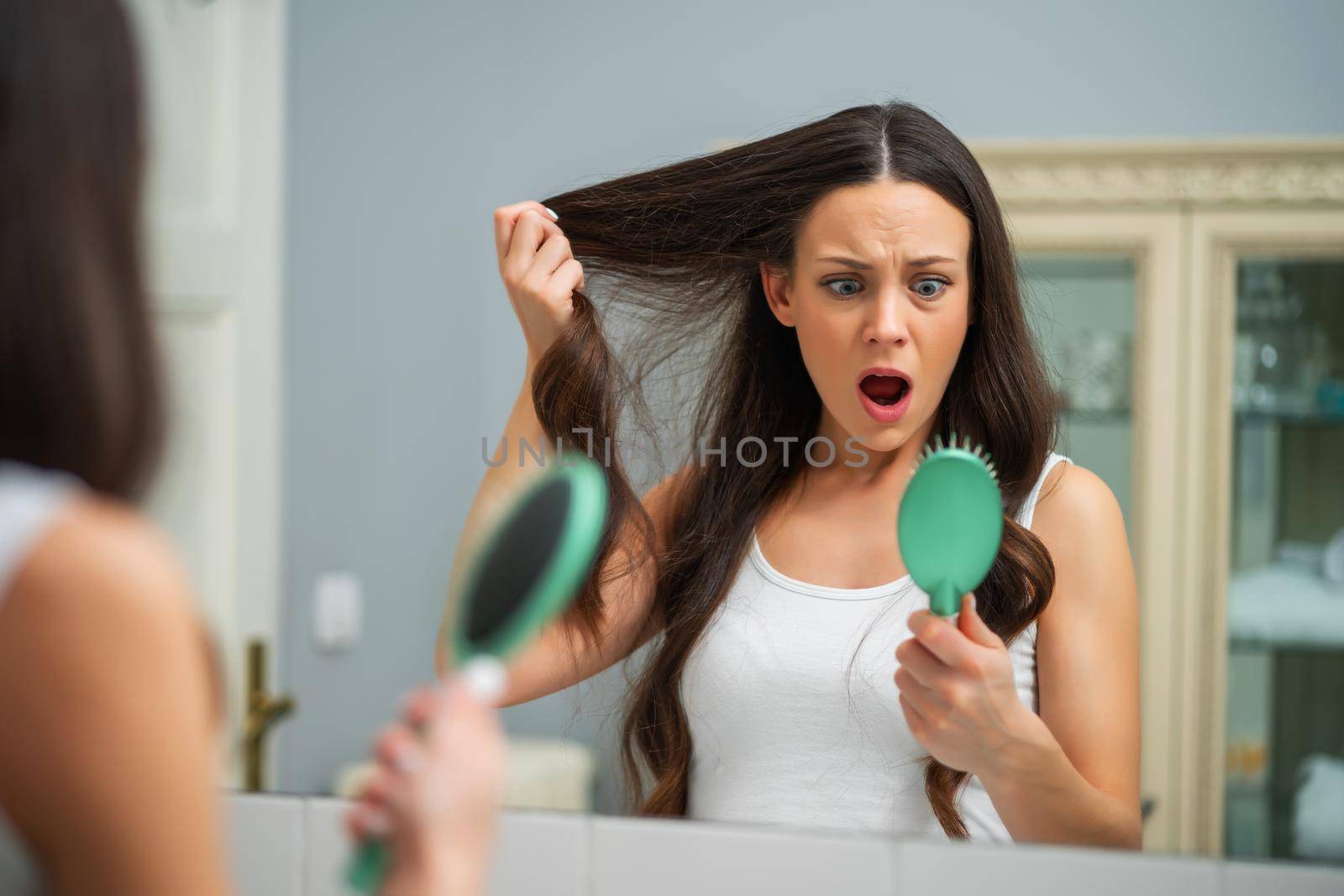 Young woman is in panic because of hair loss.