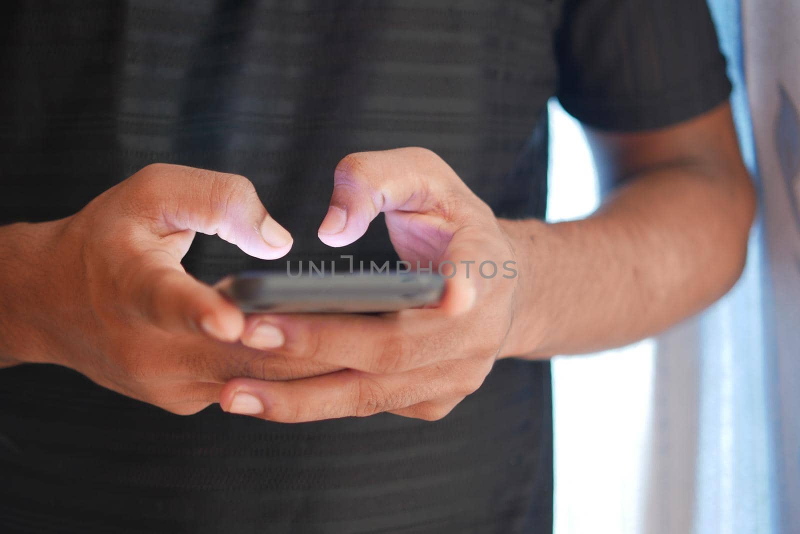 Close up of young man hand using smart phone