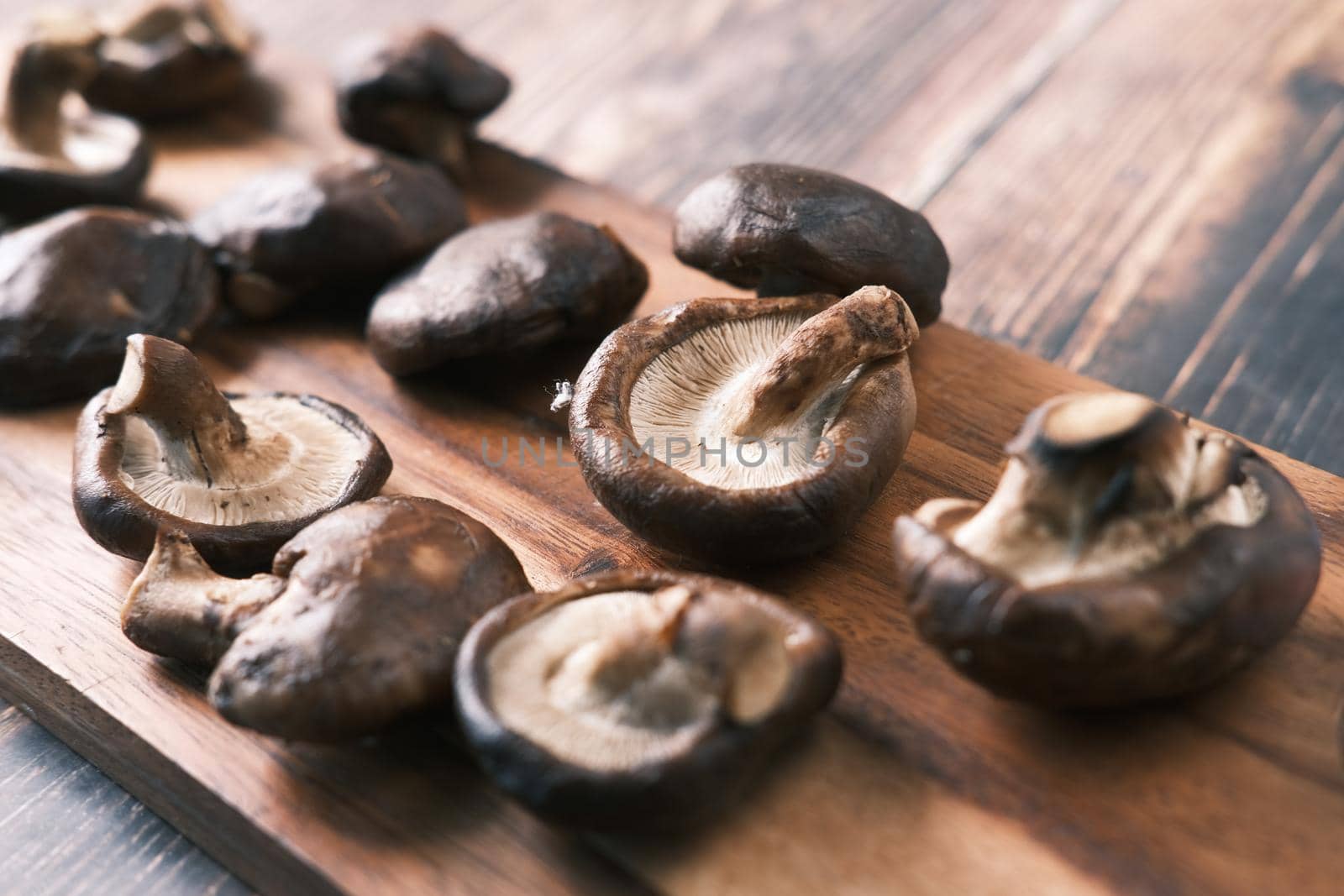 raw champignon mushroom on a chopping board on table .