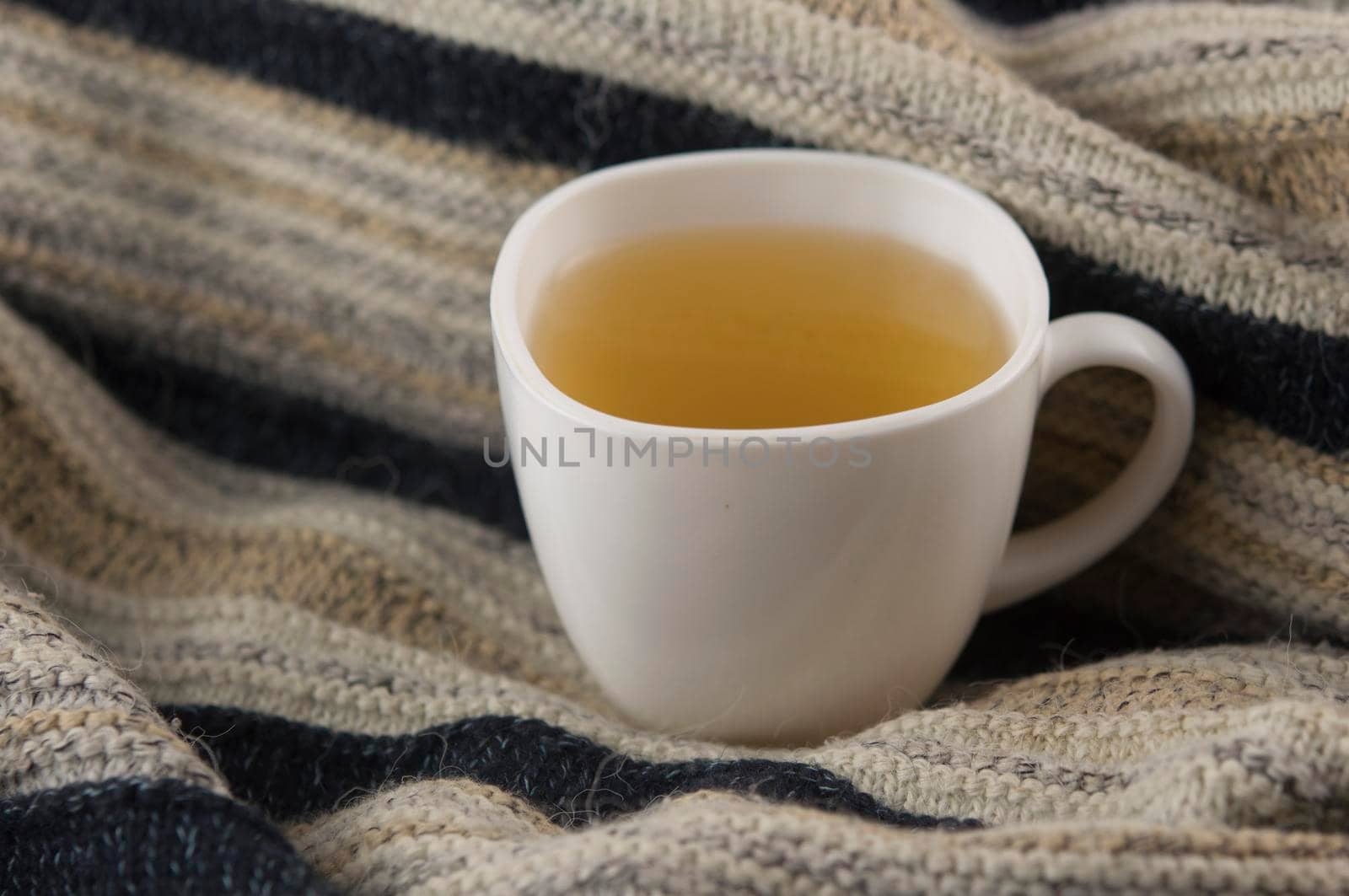 cozy autumn Breakfast with tea in white cup and a warm knitted sweater 